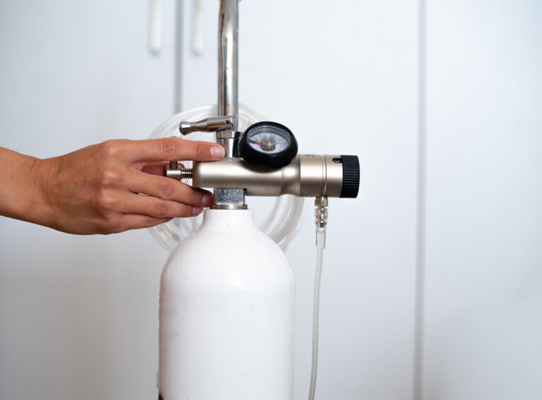 EBOO in Minneapolis | Lifespan Health 2 Hand operating a white oxygen tank regulator, representing ozone therapy