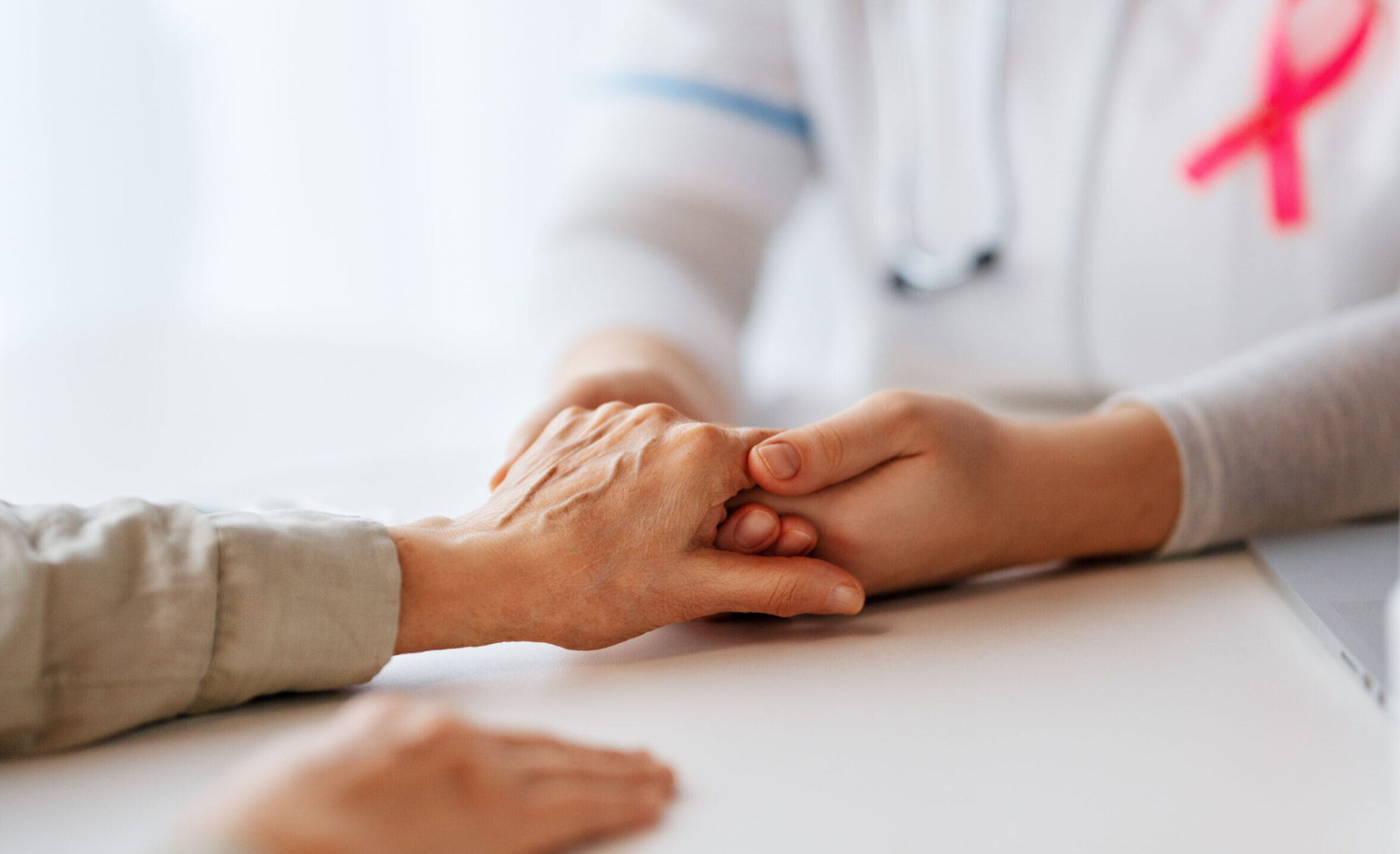 Integrative Cancer Support 1 Physician with cancer ribbon holding a patient's hand