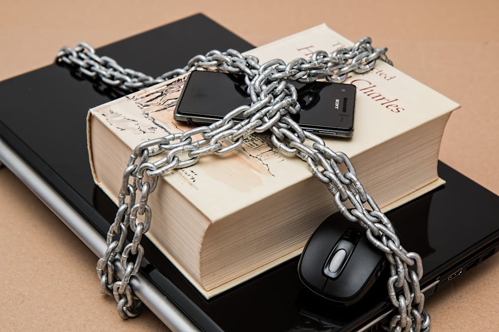 Lifespan Health's HIPAA Policy 1 Chain-locked book, phone, and laptop symbolizing digital and intellectual security, representing HIPAA Policy