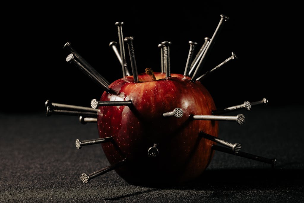 Red apple spiked with nails, representing autoimmunity